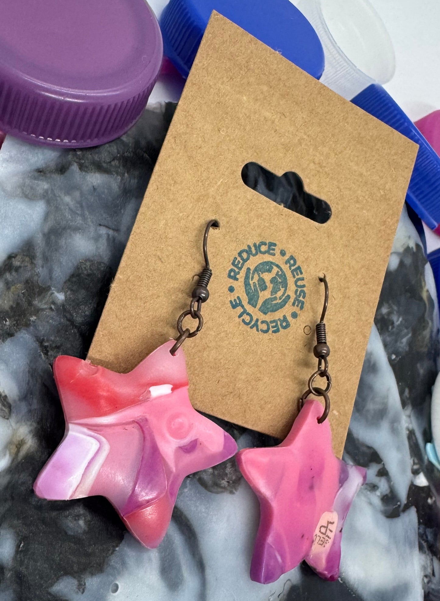 Star-shaped pink objects with a cardboard tag on a marbled surface