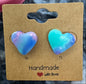 Heart-shaped earrings on a 'Handmade with Love' card against a marbled background.