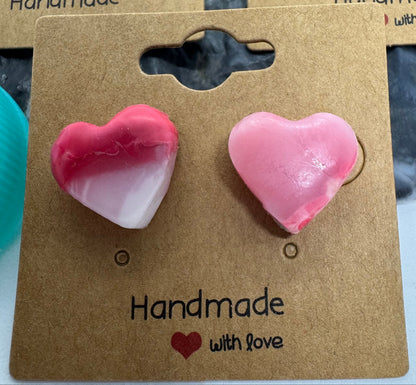 Heart-shaped pink earrings on a cardboard earring card with 'Handmade' text.