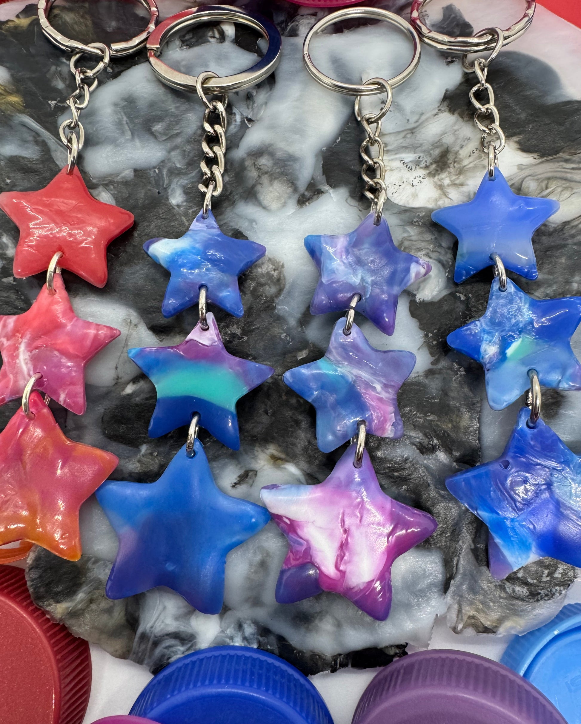 Colorful star-shaped objects on a textured surface with purple lids in the background.