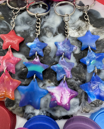 Colorful star-shaped objects on a textured surface with purple lids in the background.