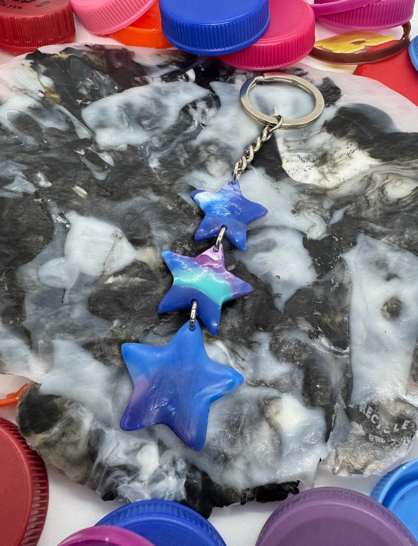 Round tray with star-shaped objects surrounded by colorful bottle caps