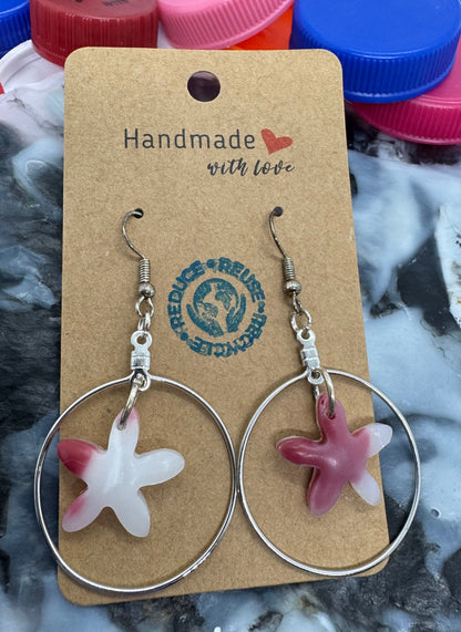 Starfish-shaped earrings on a cardboard card with 'Handmade with Love' text, against a textured background.