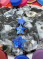 Marbled stone with blue star-shaped objects surrounded by colorful bottle caps.