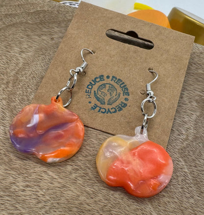 Colorful earrings on a cardboard backing with a visible brand logo.