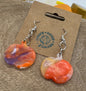 Colorful earrings on a cardboard backing with a visible brand logo.