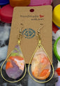 Colorful bottle caps with earrings on a white background