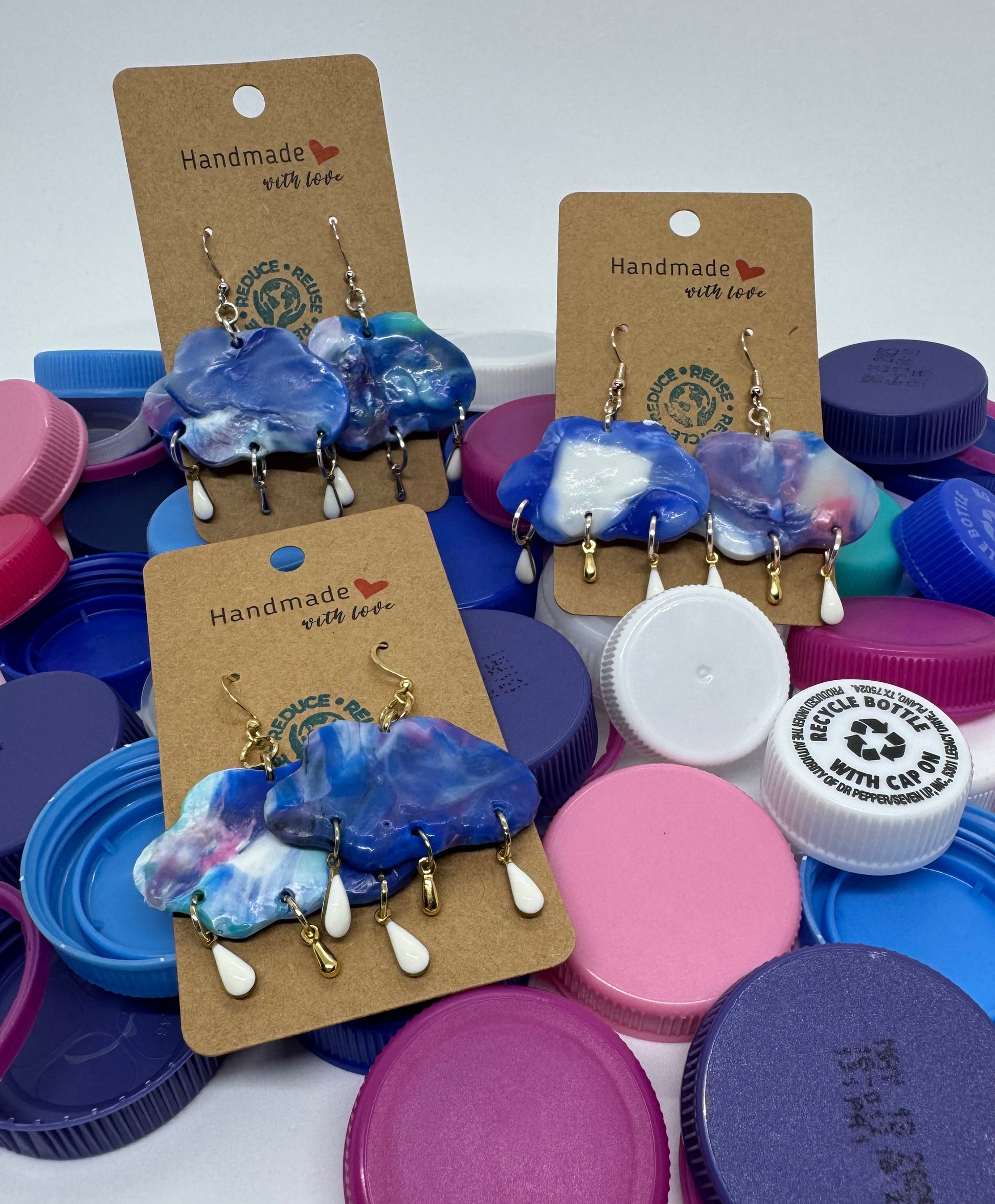 Colorful bottle caps with earrings on a white background