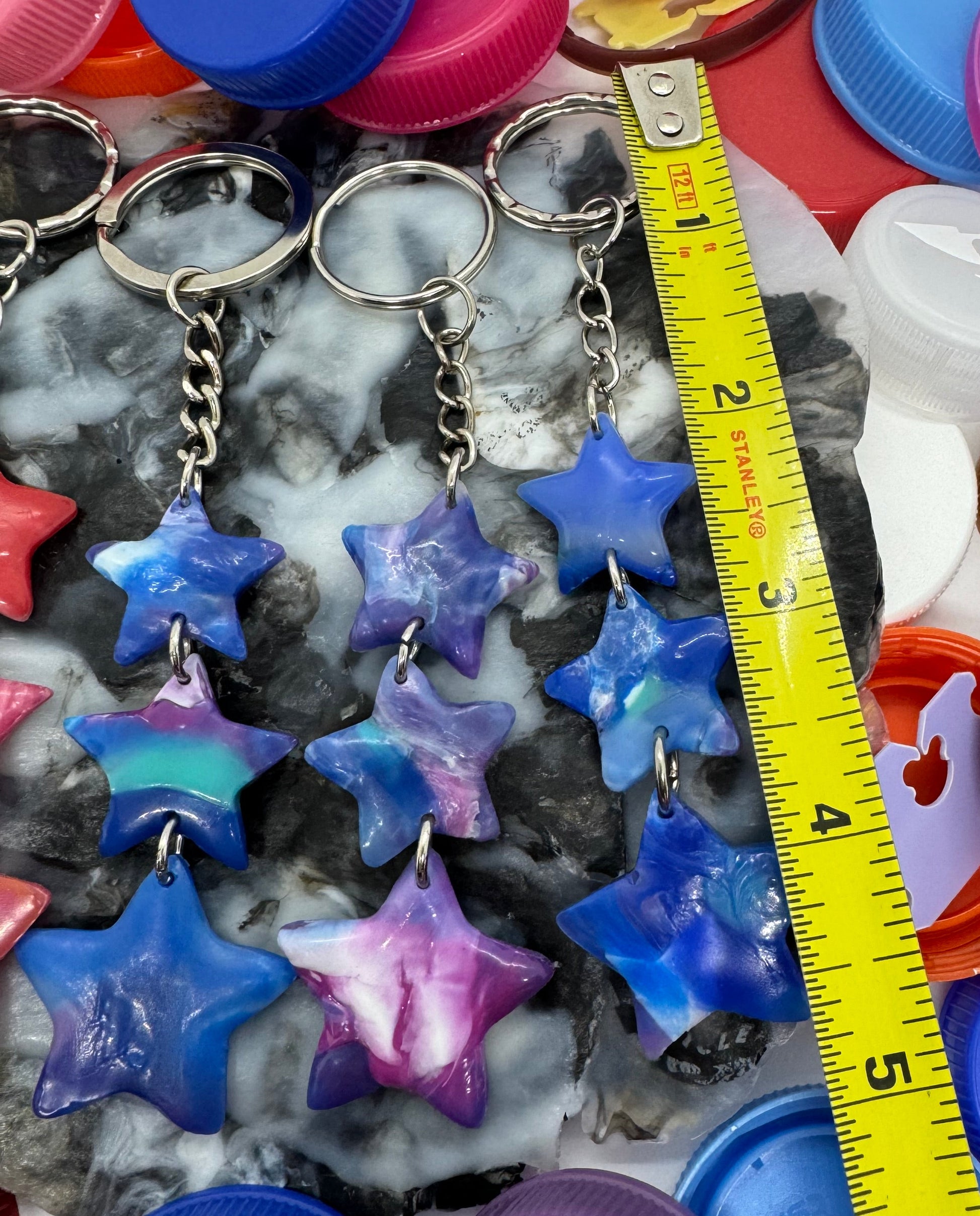Colorful bottle caps and star-shaped objects with a measuring tape on a white background