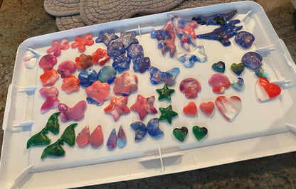 Colorful butterfly-shaped ice cubes in a tray on a kitchen counter.