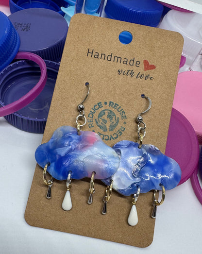Handmade jewelry on a card with colorful bottle caps in the background