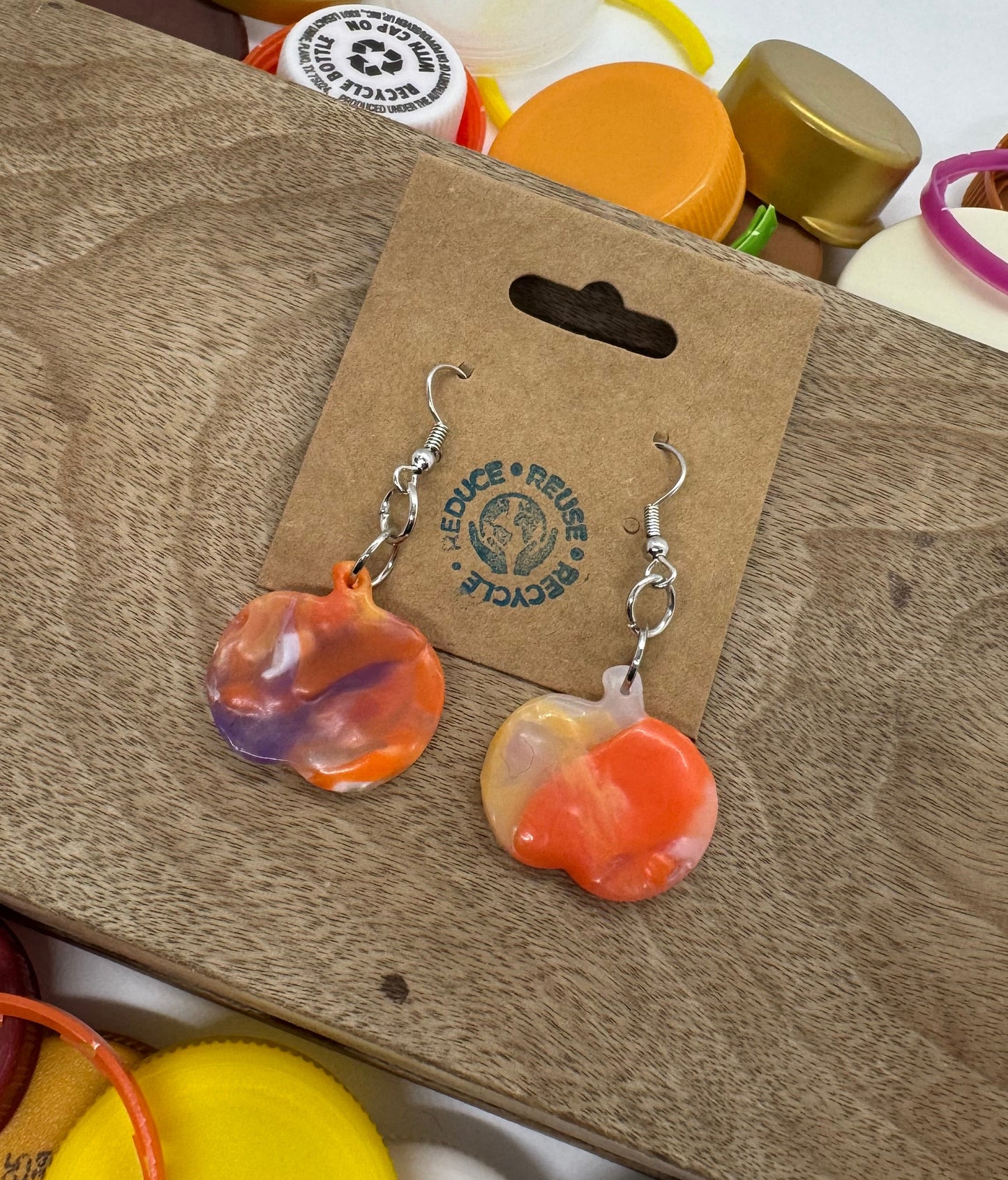 Colorful bottle caps on a cardboard surface with a visible brand label.
