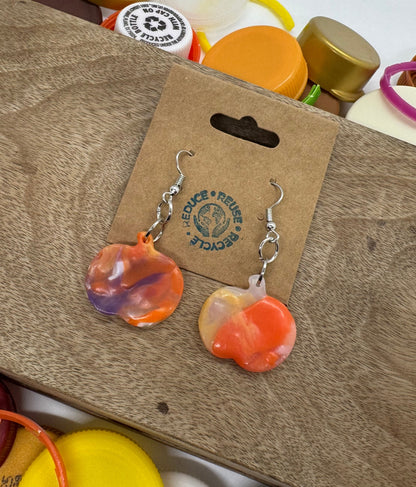 Colorful bottle caps on a cardboard surface with a visible brand label.
