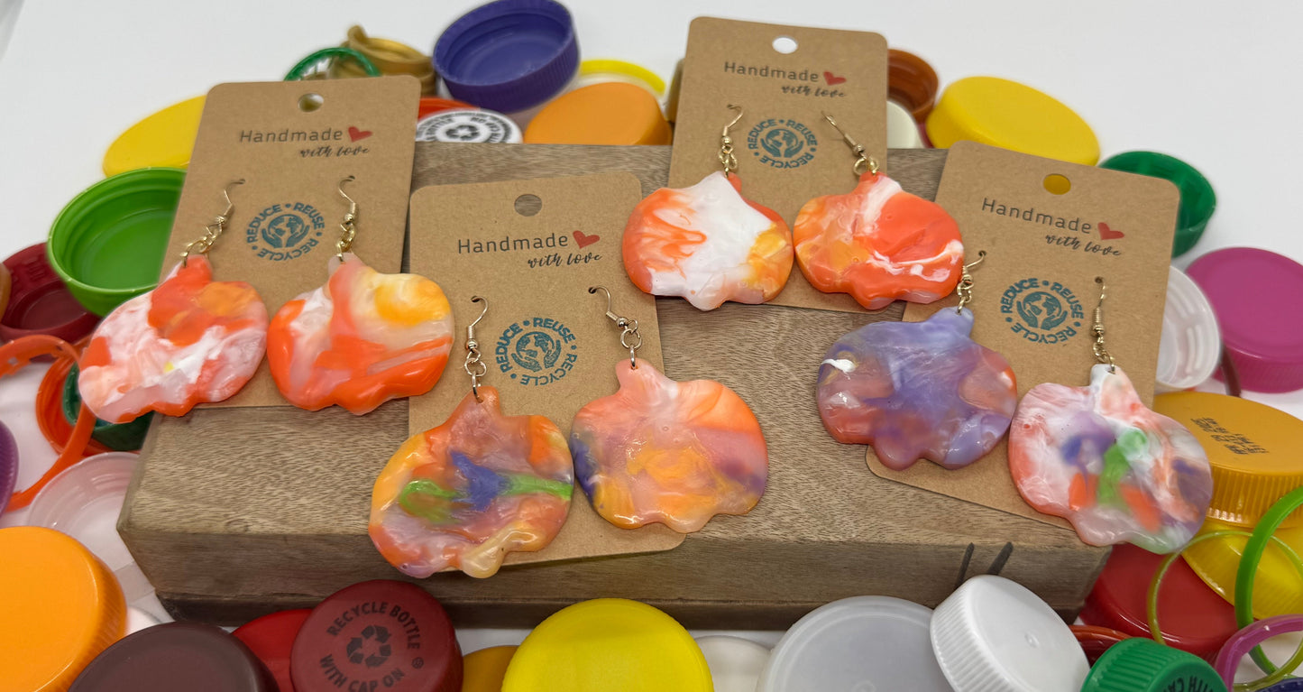 Colorful earrings on display with various bottle caps underneath