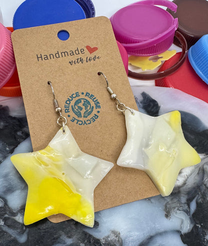 Star-shaped earrings on a cardboard tag with a marble background