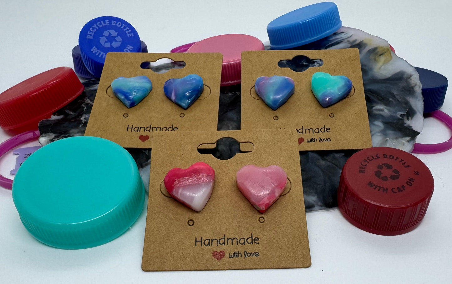 Colorful earrings on display with cardboard backings on a white background