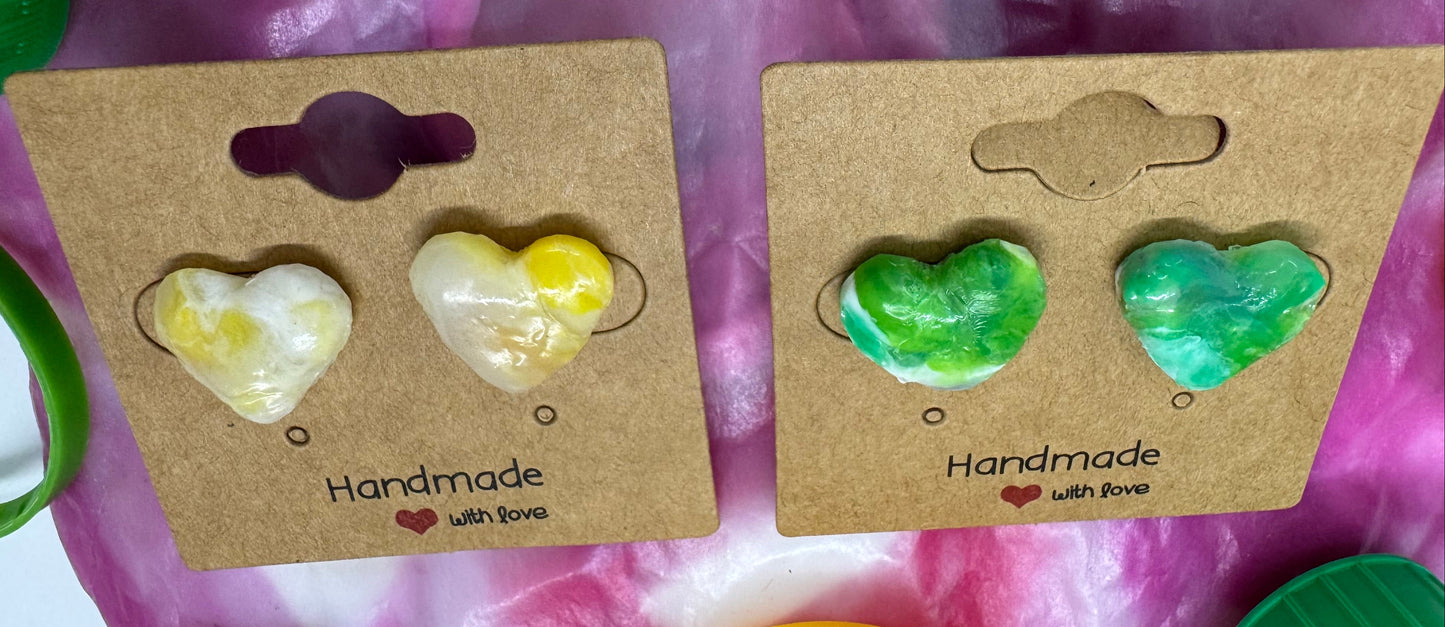 Two pairs of heart-shaped earrings on cardboard cards with a pink background.