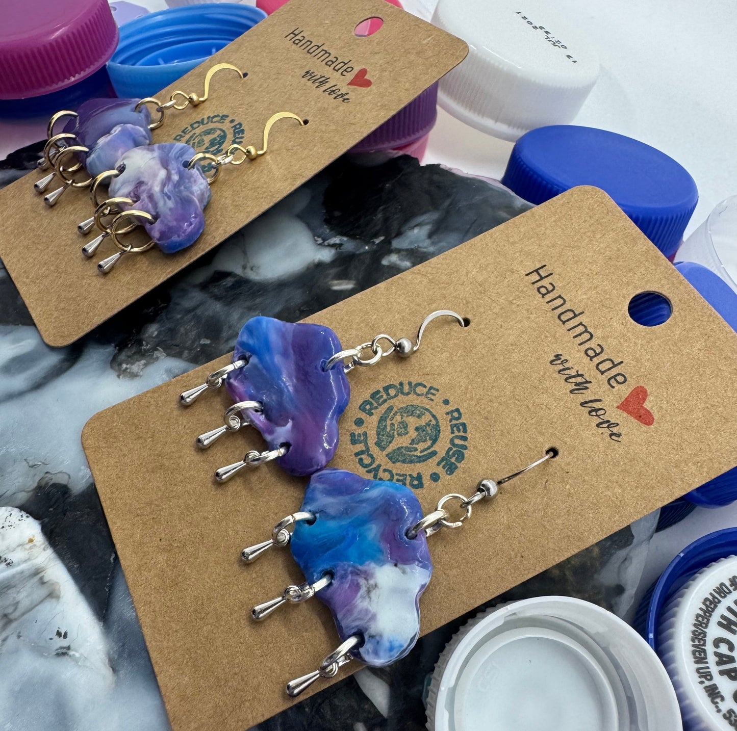 Handmade earrings on a cardboard backing with a marble pattern