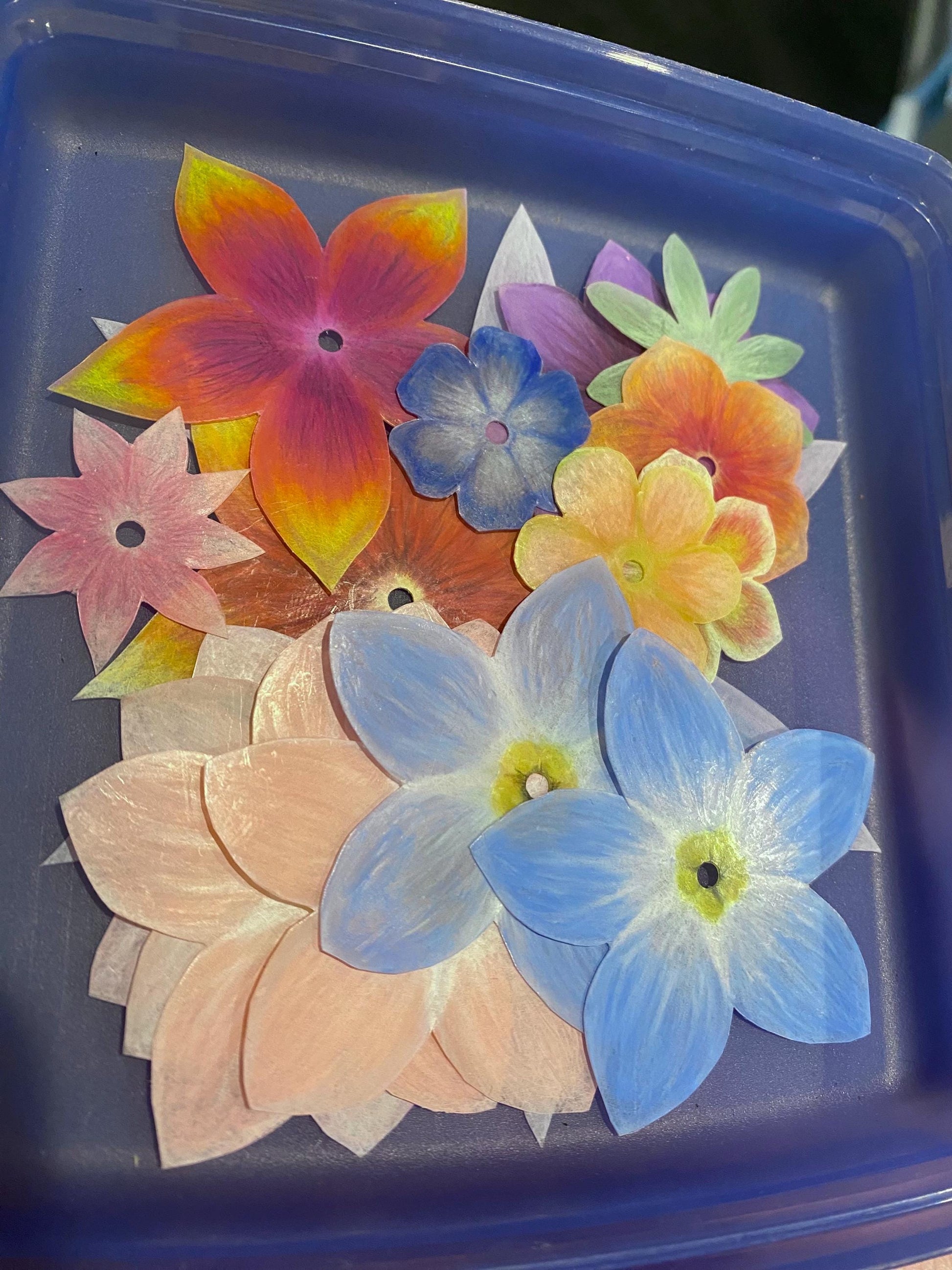 Colorful flower-shaped objects on a blue tray