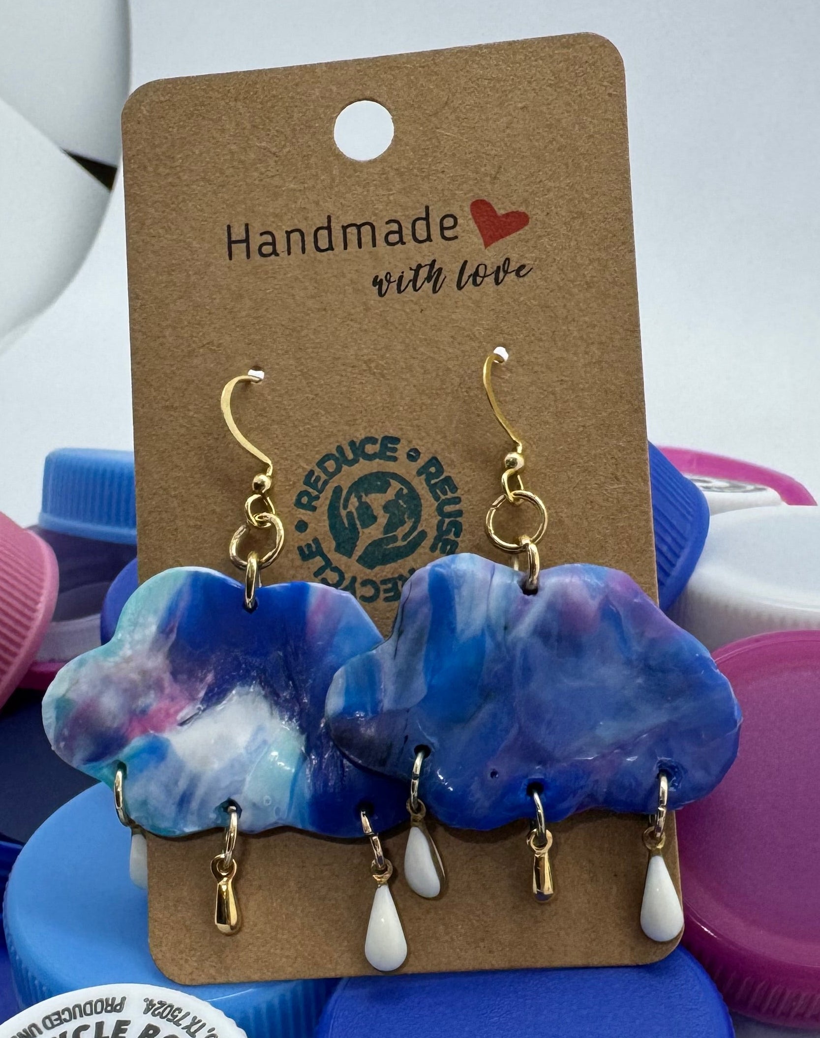 Colorful bottle caps with a pair of earrings on a tag, against a white background.