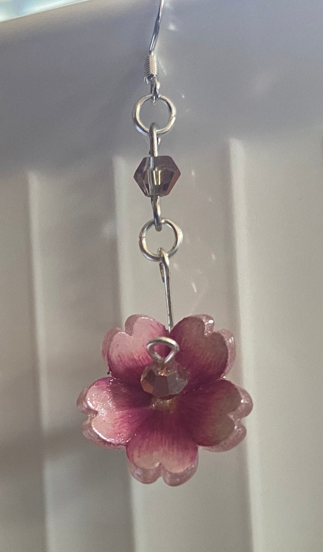 Pink flower earrings on a white surface
