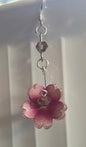 Pink flower earrings on a white surface