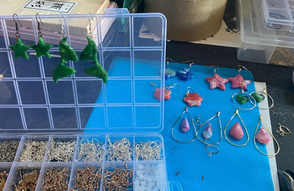 Jewelry display with earrings and clasps on a blue mat
