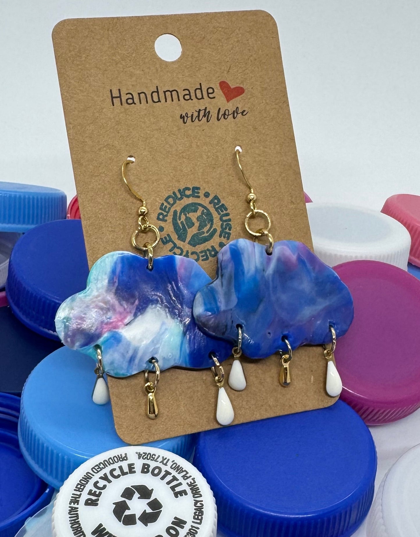 Colorful bottle caps with earrings on a white background