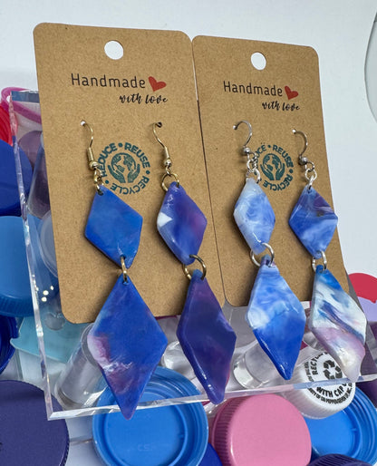 Necklace on display cards with colorful bottle caps in the background