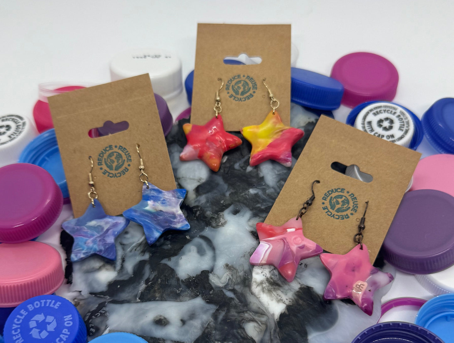 Assorted colorful plastic bottle caps and earrings on a white background