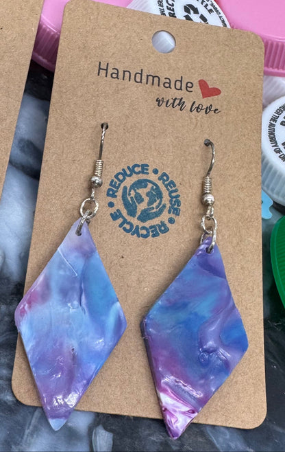Colorful earrings on display with a brand logo and 'Handmade with Love' text against a colorful background.