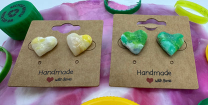 Two pairs of earrings on cardboard cards with a colorful background