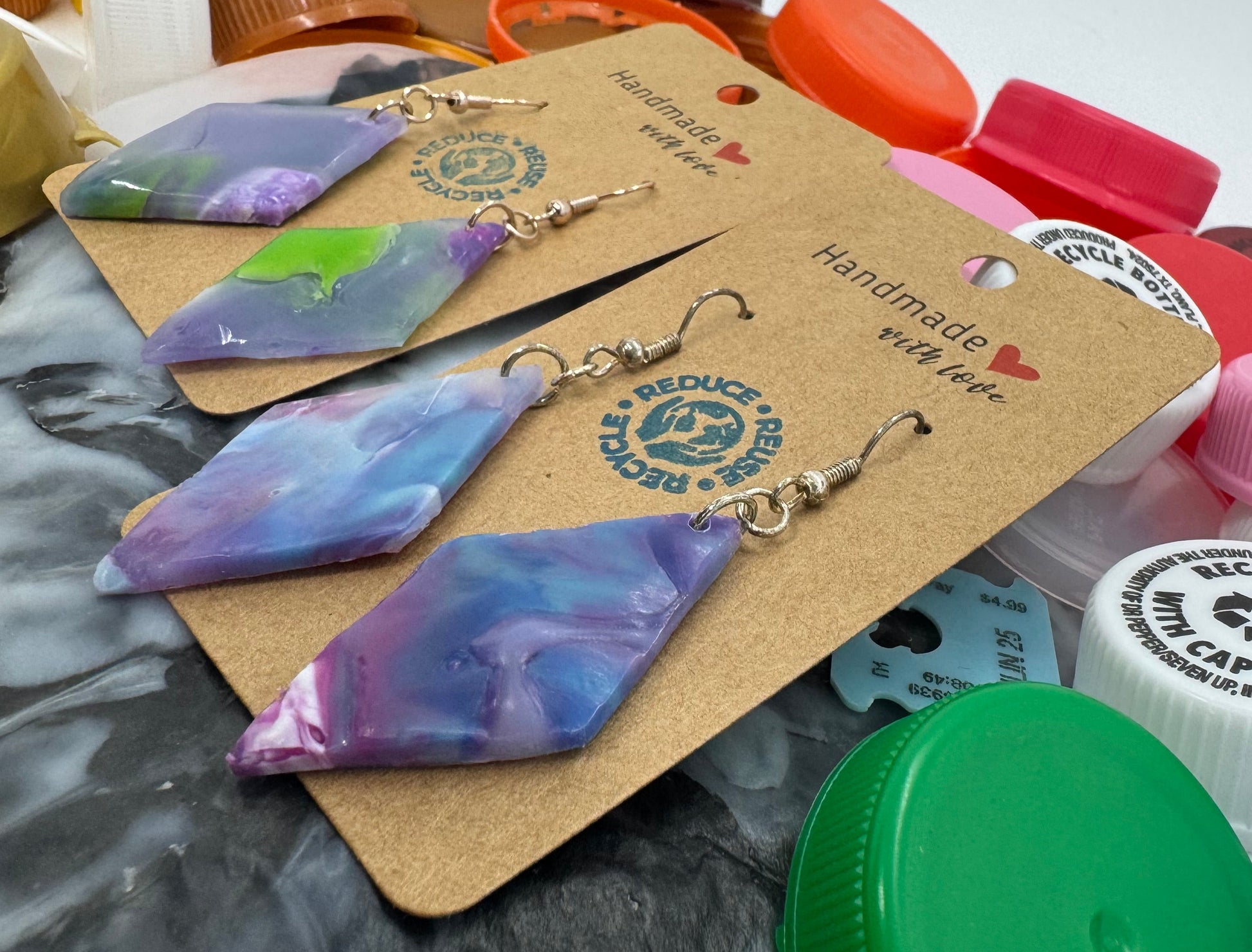 Colorful bottle caps with a keychain and packaging on a textured surface