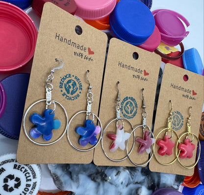 Star-shaped keychains on display with cardboard tags, surrounded by colorful bottle caps.