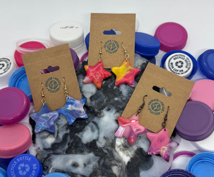 Colorful bottle caps and earrings on a white background