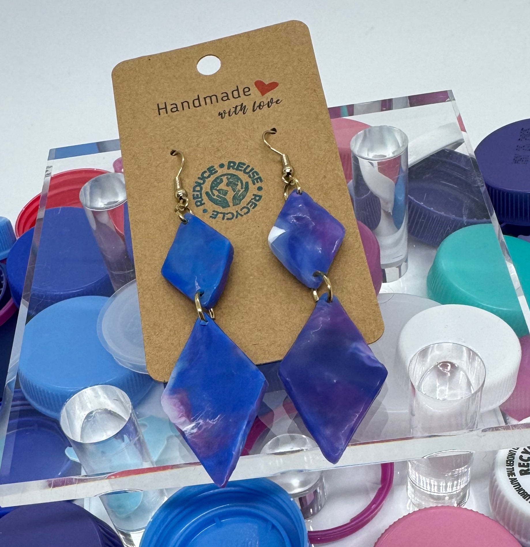 Colorful plastic bottle caps with a 'Handmade' label on a white background