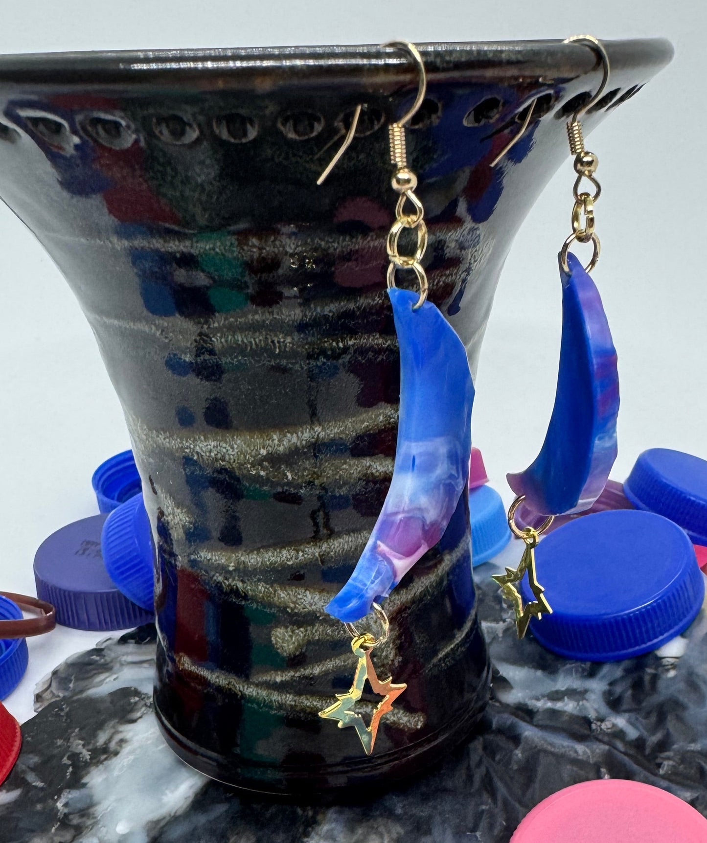 Colorful bottle caps scattered around a decorative item with a white background