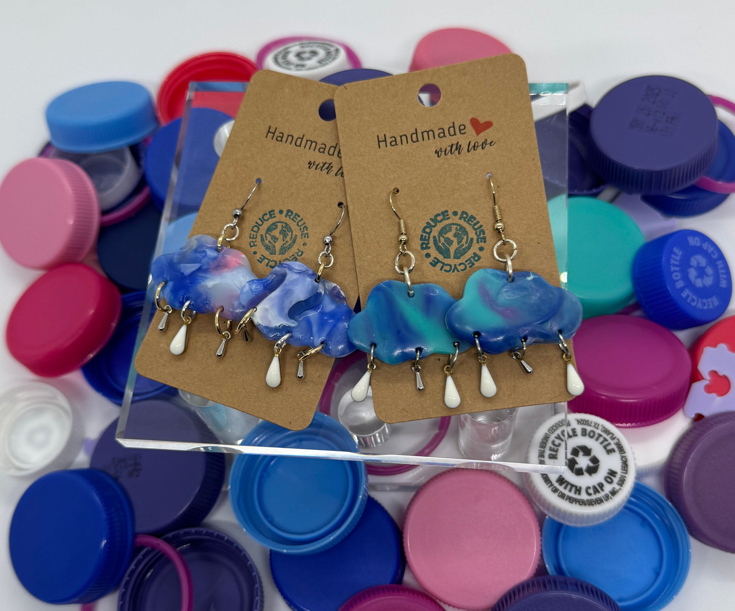 Colorful bottle caps with earrings on a white background
