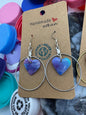 Heart-shaped earrings on a 'Reuse Recycle' card with colorful bottle caps in the background